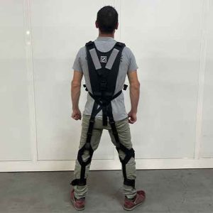 Homme portant un exosquelette dans un atelier.